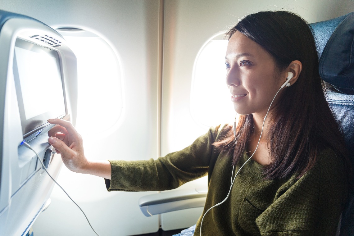 A woman passenger selecting programmes from the inflight entertainment system